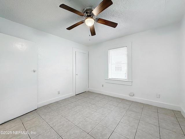 empty room with ceiling fan and a textured ceiling