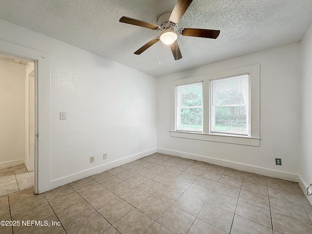 tiled empty room featuring ceiling fan and a textured ceiling