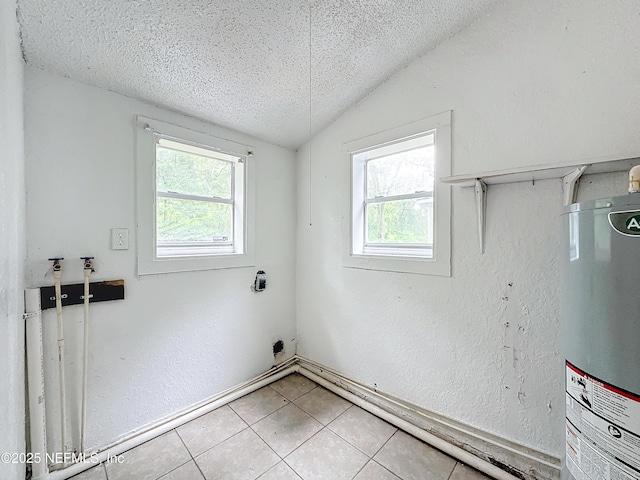 laundry area featuring electric dryer hookup, a healthy amount of sunlight, electric water heater, and a textured ceiling