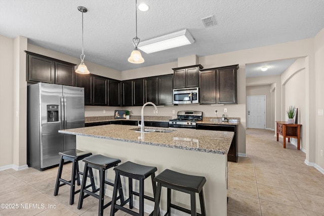 kitchen featuring light tile patterned flooring, stainless steel appliances, sink, and a textured ceiling