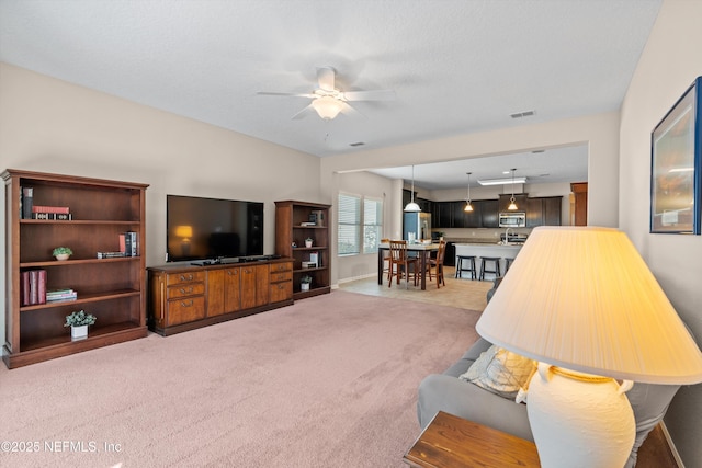 carpeted living room with ceiling fan