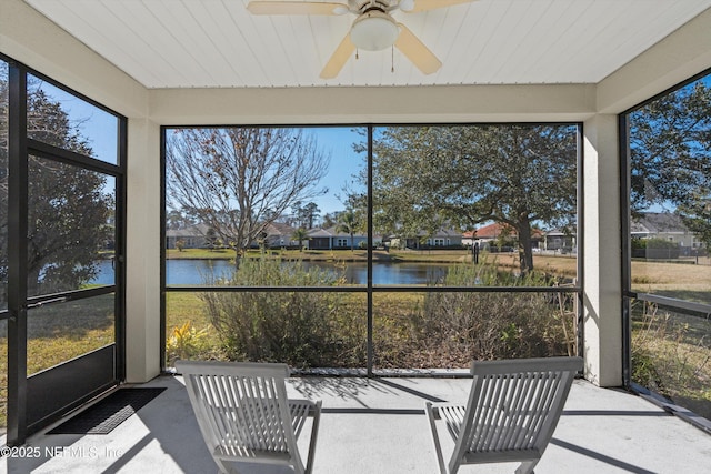 sunroom / solarium featuring a water view and ceiling fan