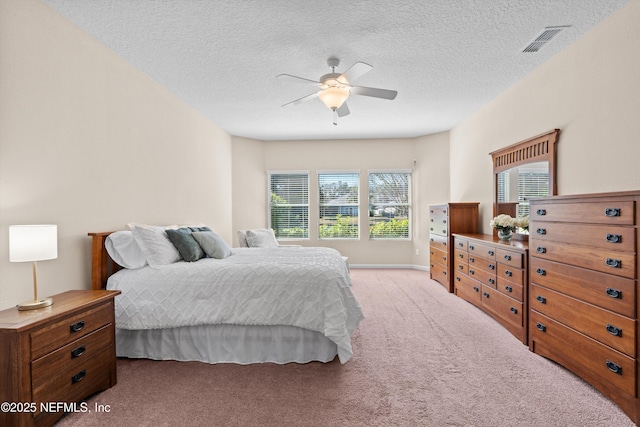 bedroom featuring a textured ceiling, ceiling fan, and carpet