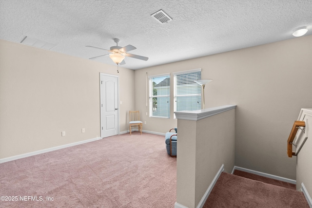 misc room featuring ceiling fan, carpet flooring, and a textured ceiling