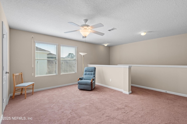 unfurnished room featuring light carpet, ceiling fan, and a textured ceiling