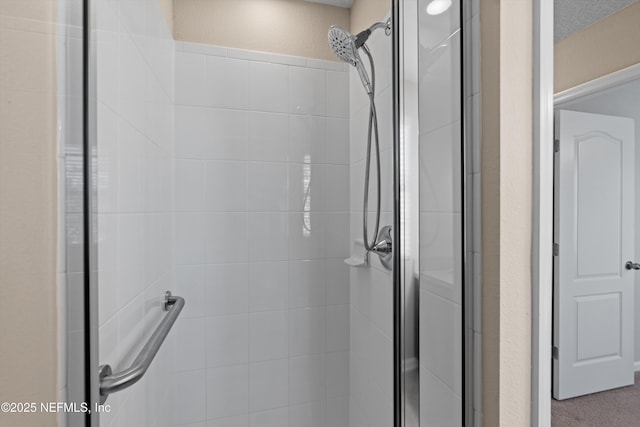 bathroom featuring a textured ceiling and walk in shower