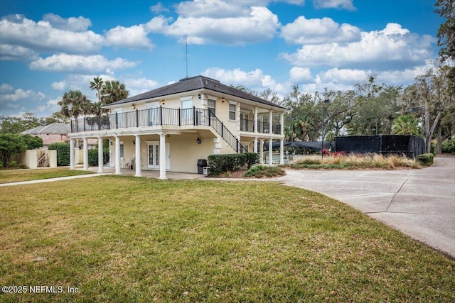 view of front of house featuring a front lawn and a balcony