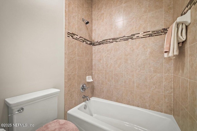 bathroom with tiled shower / bath and toilet