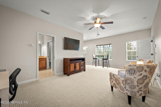 interior space featuring light carpet, a textured ceiling, and ceiling fan