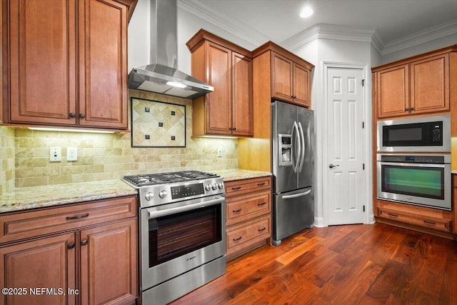 kitchen with appliances with stainless steel finishes, dark hardwood / wood-style floors, ornamental molding, light stone countertops, and wall chimney range hood