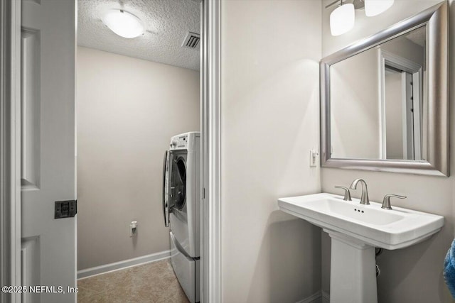 laundry room featuring washer / dryer and a textured ceiling