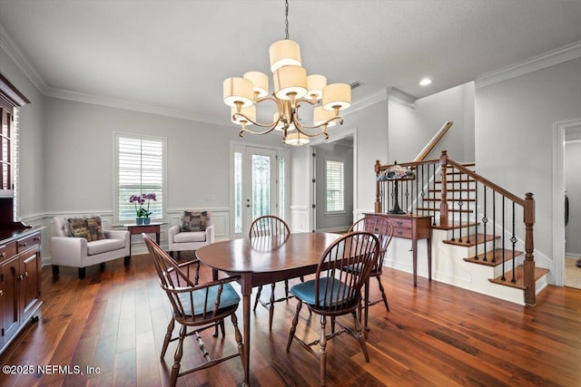 dining space with dark wood-type flooring, ornamental molding, and a chandelier