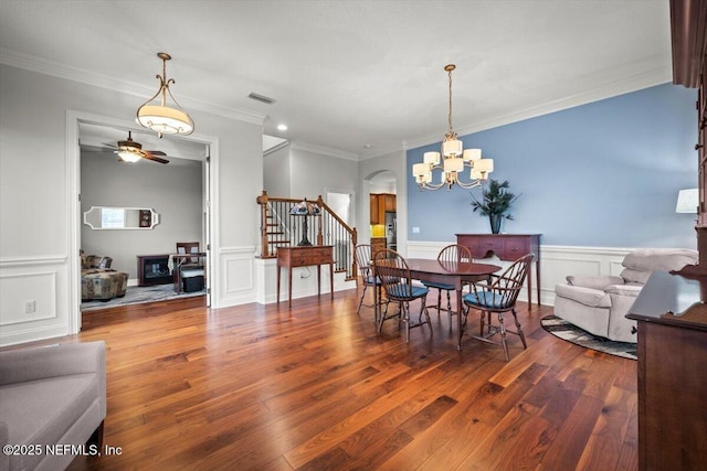 dining room with crown molding, wood-type flooring, and a chandelier