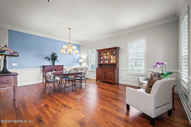 dining space with ornamental molding, dark hardwood / wood-style floors, and a chandelier