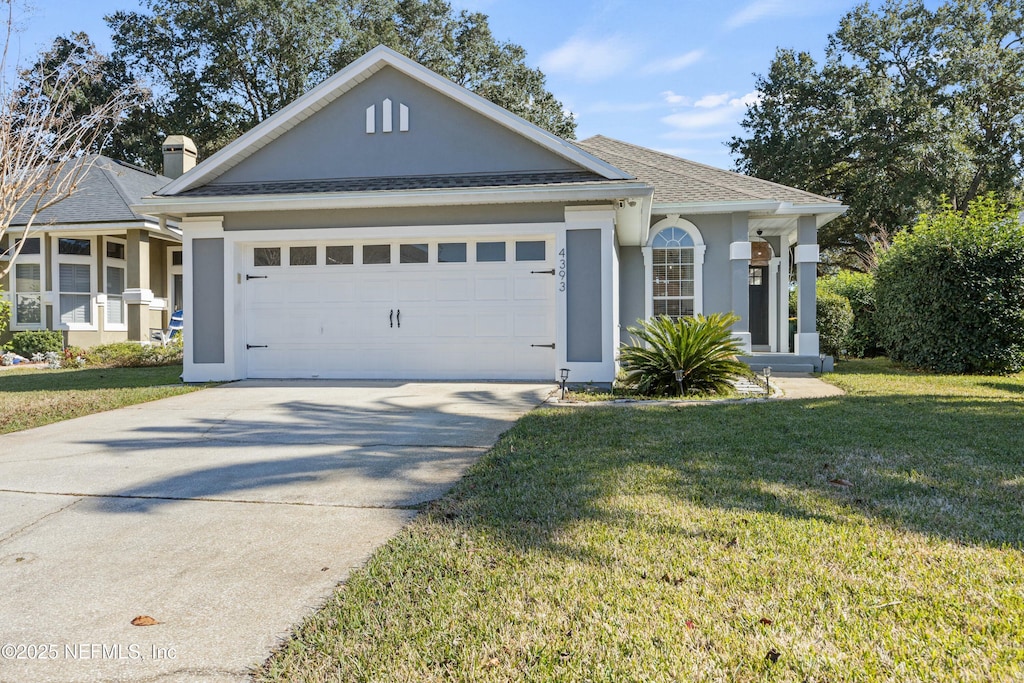 view of front of house with a garage and a front lawn