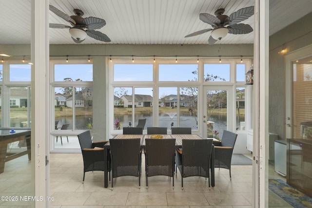 sunroom with a water view and ceiling fan