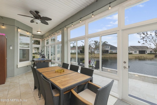 sunroom with a water view, ceiling fan, and a healthy amount of sunlight