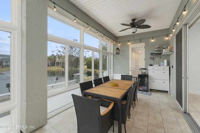 sunroom with a water view, ceiling fan, and a wealth of natural light