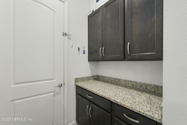 interior space with dark brown cabinetry and light stone counters