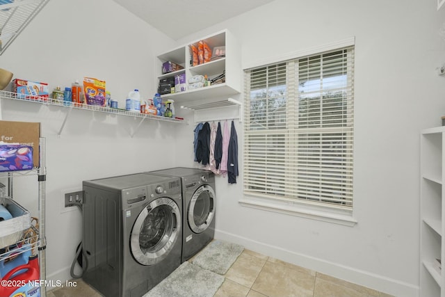 clothes washing area featuring washing machine and dryer and light tile patterned flooring