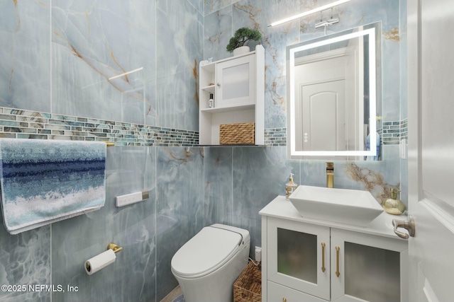 bathroom with vanity, tile walls, and toilet