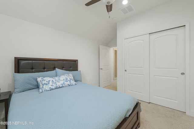 carpeted bedroom featuring ceiling fan, vaulted ceiling, and a closet