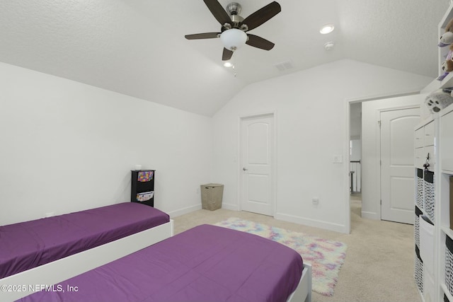 bedroom with lofted ceiling, light colored carpet, a textured ceiling, and ceiling fan