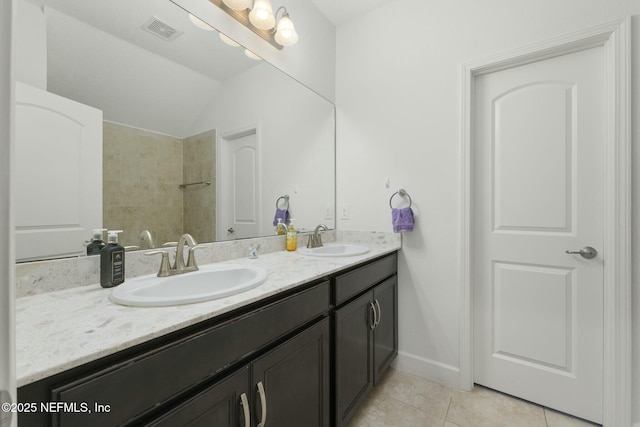 bathroom featuring tile patterned flooring, vanity, and lofted ceiling