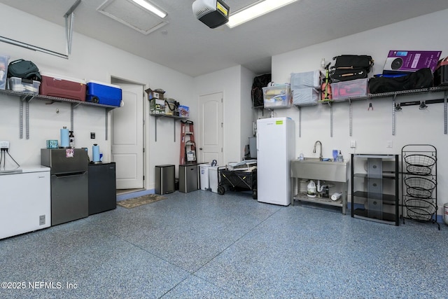 garage with sink, a garage door opener, fridge, and stainless steel refrigerator