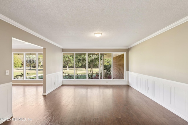 spare room with hardwood / wood-style flooring, crown molding, and a textured ceiling