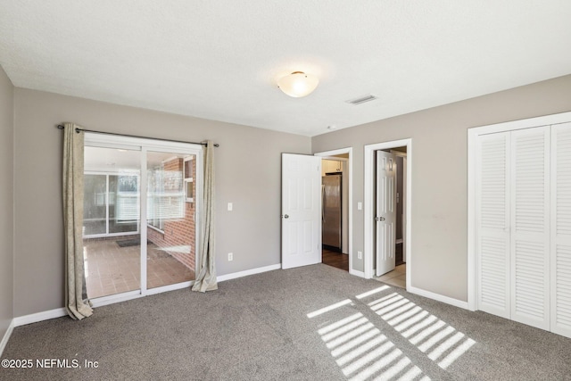 unfurnished bedroom featuring ensuite bathroom, carpet, stainless steel fridge, and a closet