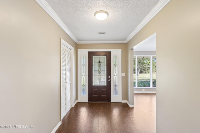 foyer entrance featuring ornamental molding, dark hardwood / wood-style flooring, and a textured ceiling