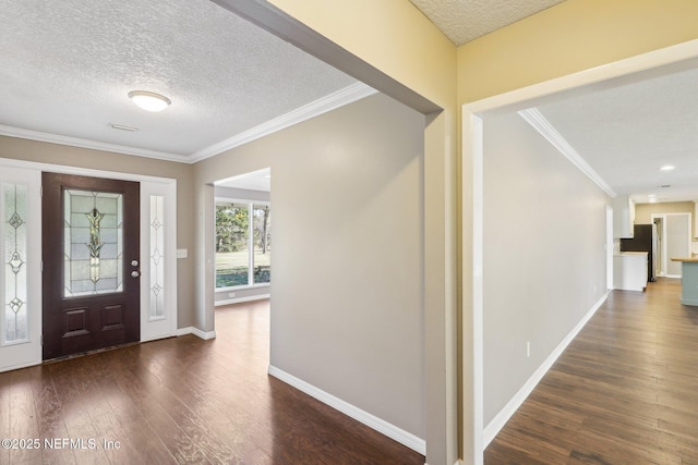 foyer entrance with ornamental molding, dark hardwood / wood-style flooring, and a textured ceiling