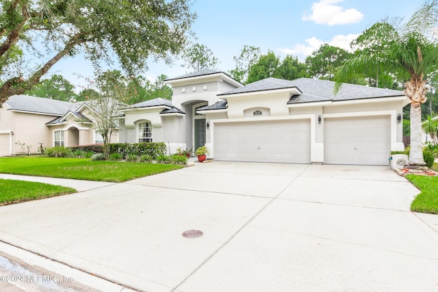 view of front of home with a garage and a front lawn