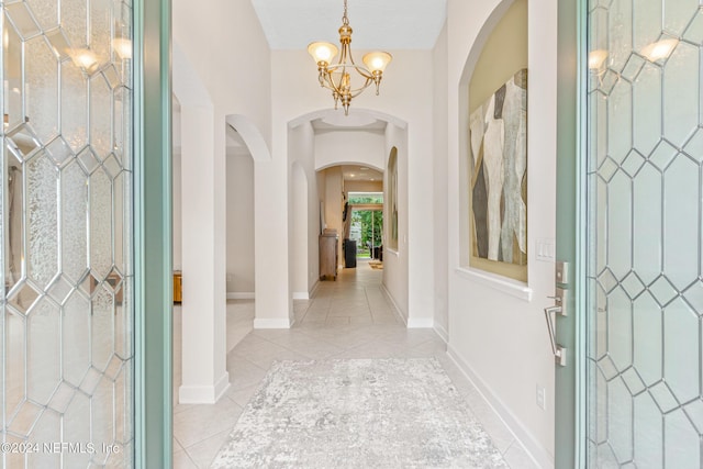 tiled entrance foyer featuring a chandelier