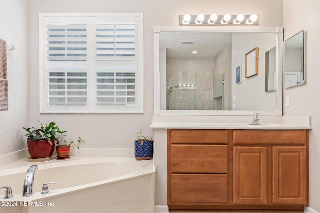 bathroom with vanity and shower with separate bathtub