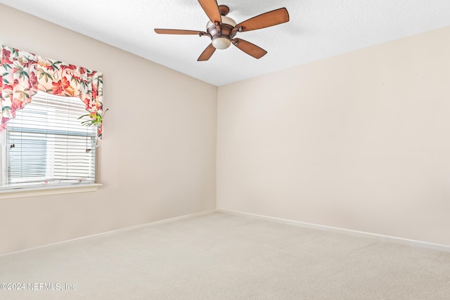 carpeted empty room featuring ceiling fan and a textured ceiling