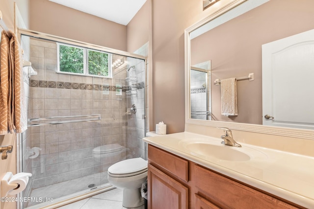 bathroom featuring vanity, tile patterned flooring, a shower with shower door, and toilet