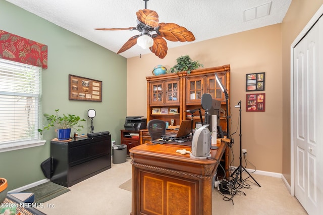 office featuring ceiling fan, light carpet, and a textured ceiling