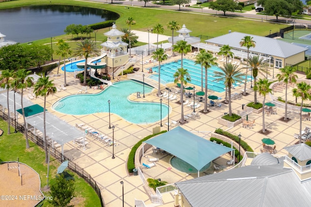 view of pool with a patio, a water view, and a water slide