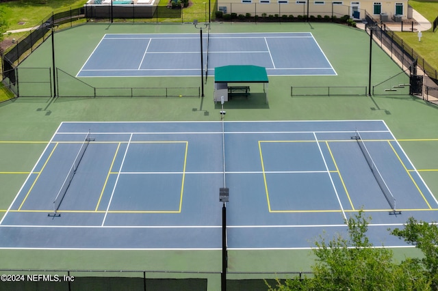 view of tennis court with basketball hoop