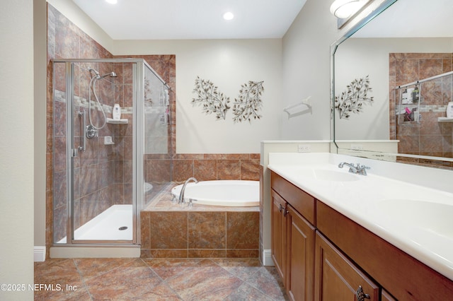 bathroom with vanity and shower with separate bathtub