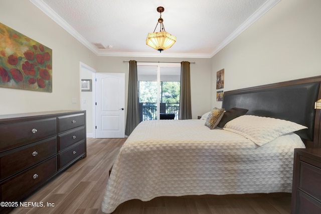 bedroom featuring ornamental molding, wood-type flooring, and a textured ceiling