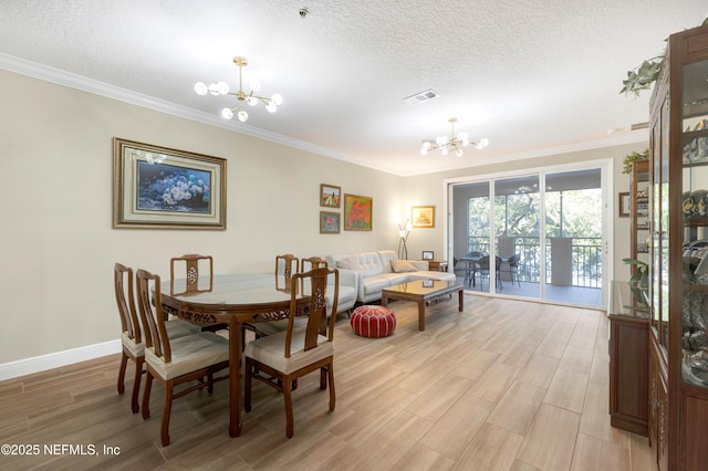 dining space featuring a notable chandelier, ornamental molding, and a textured ceiling