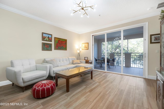 living room featuring crown molding, light wood-type flooring, and an inviting chandelier