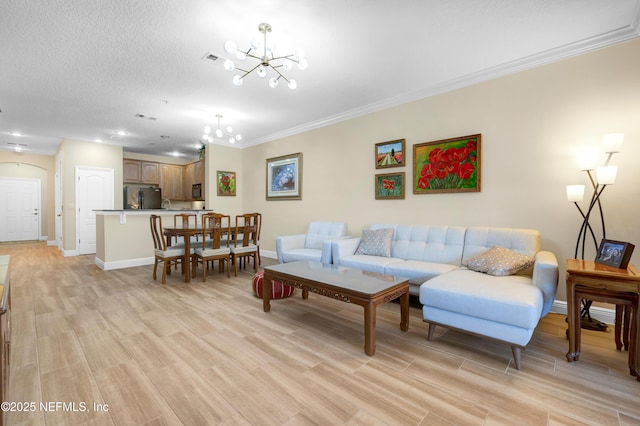 living room with crown molding, light wood-type flooring, a textured ceiling, and a chandelier