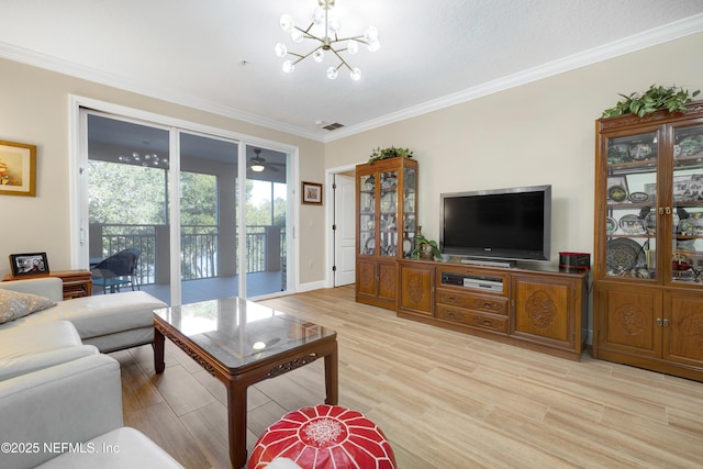 living room with ornamental molding, a notable chandelier, and light hardwood / wood-style floors