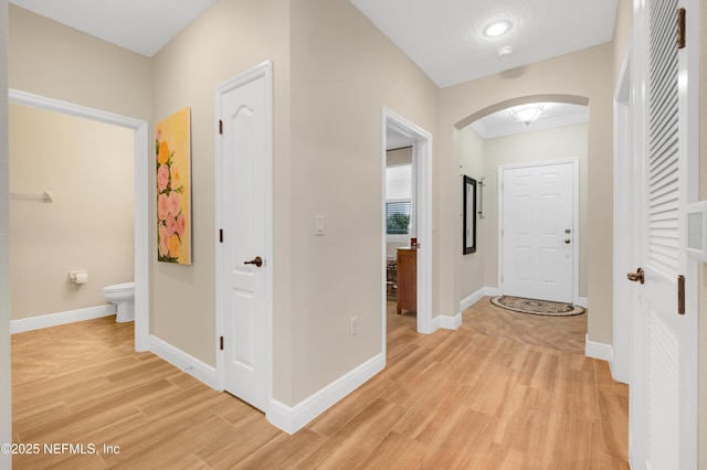 foyer featuring crown molding and light hardwood / wood-style floors