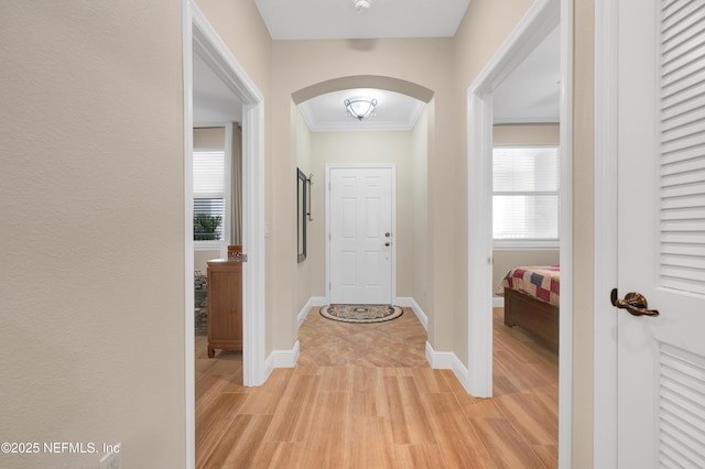 entryway with crown molding and light hardwood / wood-style flooring