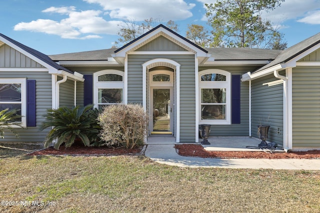 view of exterior entry featuring a yard